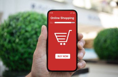 Yeşil stree ekranının arka planında uygulama alışverişi yapan bir adam telefonu tutuyor