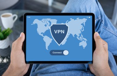 Erkekler kafeterya ofisindeki ekranda VPN uygulamalı bilgisayar tabletini tutarlar