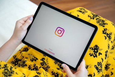 Alanya, Türkiye - 27 Mayıs 2021: Kadın el ele tutuşması iPad Air ile sosyal ağ hizmeti Instagram ekranda.