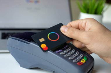 Alanya, Türkiye - 4 Nisan 2024: Erkek el ele tutuşan plastik kart Payonetici Mastercard ve çevrimiçi POS terminal geçiş kartı