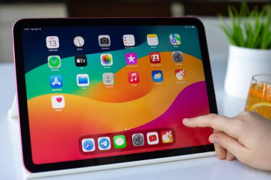 Alanya, Türkiye - 13 Nisan 2024: Ana ekranda Apple iPad IOS 17 'yi tutan çocukların elleri. Apple iPad Apple tarafından oluşturuldu ve geliştirildi.