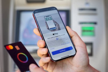 Alanya, Türkiye - 12 Mart 2024: Elde tutulan iPhone 15 Pro Max uygulamalı Apple Pay Cash ekran ve kart Mastercard. iPhone 15 Apple Inc. tarafından oluşturuldu ve geliştirildi.