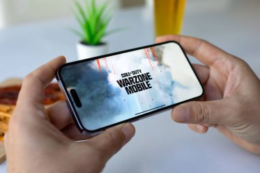 Alanya, Türkiye - 3 Mayıs 2024: Elleri ekranda Call of Duty Mobile oyunu ile Apple iPhone 15 Pro Max 'i tutuyor. Games Call of Duty Activision Yayıncılık, Inc..