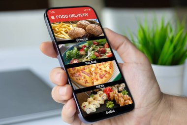 kafenin arka planında yemek dağıtım uygulaması olan bir adam el ele tutuşur.