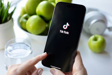Alanya, Türkiye - 30 Mayıs 2024: Kadın eli Apple iPhone 15 Pro Max 'i canlı yayın servis medyası ve video TikTok ile ekranda tutuyor.