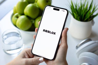 Alanya, Türkiye - 30 Mayıs 2024: Kadın elleri Apple iPhone 15 Pro Max 'i çok oyunculu online oyun Roblox cep telefonuyla ekranda IOS telefonunda tutuyor.