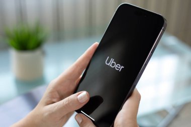 Alanya, Türkiye - 21 Temmuz 2024: Kadın el ele tutuşması iPhone 15 Pro Maksimum Taksi uygulaması ekranda