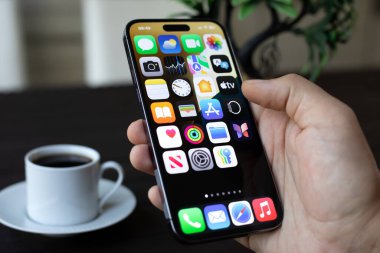 Alanya, Türkiye - 11 Temmuz 2024: Elle tutulan Apple iPhone 15 Pro Max ve ekranda IOS 18