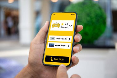 Ekran arka planında taksi çağırma uygulaması olan erkek el telefonu.