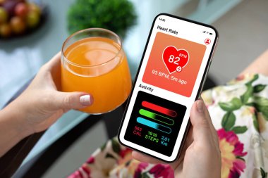 Kadın cep telefonu uygulamalı ve kafenin arka planında faaliyet gösteren bir uygulama.