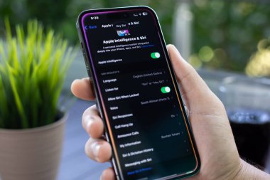 Alanya, Türkiye - 31 Temmuz 2024: Apple iPhone 15 Pro Max 'in ana ekran IOS 18 AI Apple Intelligence Siri ile el ele tutuşması.