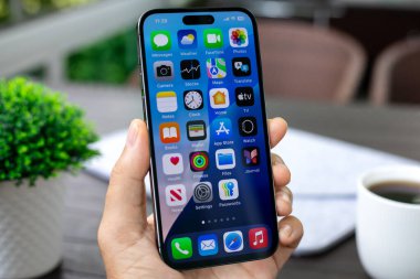 Alanya, Türkiye - 10 Ağustos 2024: Apple iPhone 15 Pro Max 'in ana ekran IOS 18 AI Apple Intelligence Siri ile el ele tutuşması ekranda.