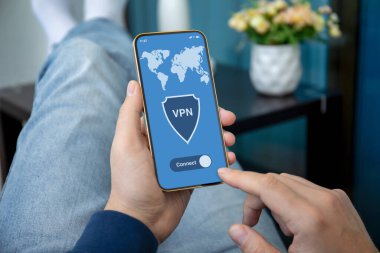 Erkek eller, odadaki kot pantolonların ekranında uygulamalı VPN ile telefonu tutuyor.