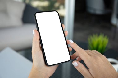 Ofiste izole edilmiş arka plan kafesi olan erkek eller telefonu tutuyor.