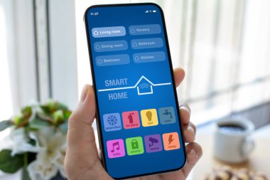 Ekran arka planında akıllı ev uygulaması olan erkek el bilgisayarı