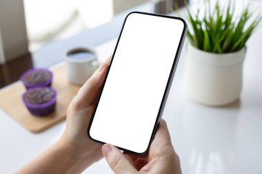 Kadın elleri, kafede kahveli, izole ekran masalı telefonu tutuyor.