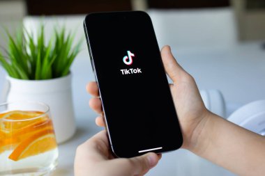 Alanya, Türkiye - 13 Nisan 2024: Çocuk elleri Apple iPhone 15 Pro Max ile ekranda servis medyası ve video TikTok.