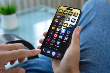 Alanya, Türkiye - 16 Temmuz 2024: Elle tutulan Apple iPhone 15 Pro Max ile ana ekran IOS 18 ekranda