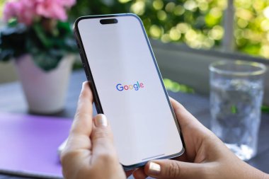 Alanya, Türkiye - 17 Ağustos 2024: Elma iPhone 15 Pro Max 'i tutan kadın eli ile sosyal ağ hizmeti Google ekranda