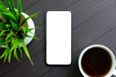 İzole edilmiş ekranlı ahşap masa ve ofisinde kahve olan telefon. 