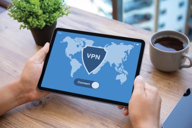 Erkek eller ekranda VPN uygulamalı bilgisayar tabletini tutar Ofisteki ahşap masa