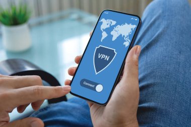 Erkek eller, odadaki kot pantolonların ekranında uygulamalı VPN ile telefonu tutuyor.