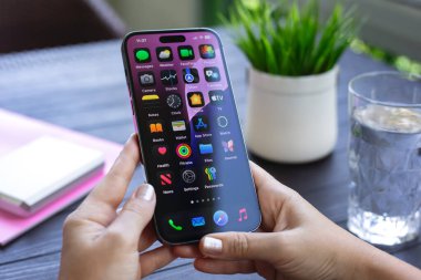 Alanya, Türkiye - 17 Ağustos 2024: Elma iPhone 15 Pro Max 'i elinde tutan kadın ekranda IOS 18 ekranı.