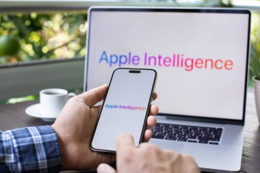 Alanya, Türkiye - 16 Eylül 2024: Apple Macbook Pro ve iPhone 15 Pro Max ile ana ekran AI Apple Intelligence Siri ile el ele tutuşan adam MacOS Sequoia ve IOS 18.