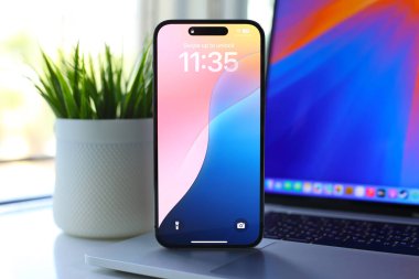Alanya, Türkiye - 25 Eylül 2024: Apple Macbook Pro ve iPhone 15 Pro Max ile ana ekran AI Apple Intelligence Siri ekranda MacOS Sequoia ve IOS 18.