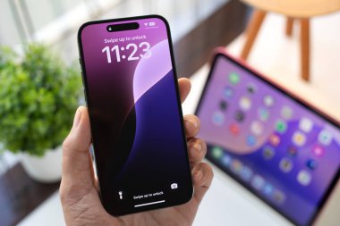 Alanya, Türkiye - 1 Ekim 2024: Apple iPhone 15 Pro Max ve iPad 'in ana ekran iOS ve iPadOS 18 AI Apple Intelligence Siri ile el ele tutuşması.