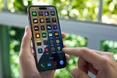 Alanya, Türkiye - 8 Ekim 2024: Elle tutulan Apple iPhone 15 Pro Max ve ekranda IOS 18.