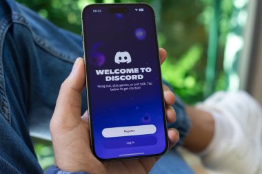 Alanya, Türkiye - 8 Ekim 2024: Erkek elleri Apple iPhone 15 Pro Max 'i Discord Video İletişim uygulamasını arayarak tutuyor