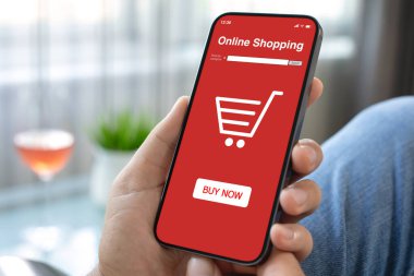 Erkek eli telefonu kırmızı online alışveriş uygulaması ile kafedeki bir bardak şarabın ekranında tutuyor.