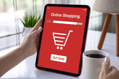 Apartmanın arka planında kırmızı online alışveriş uygulamalı bilgisayar tableti tutan kadın elleri