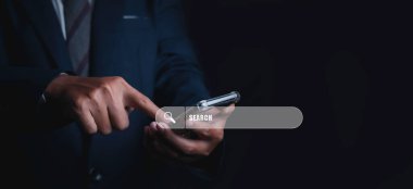Searching browsing internet data information networking concept. Search Engine Optimization SEO Networking. Man hand presses the information search button on mobile phone touch screen, copy space.