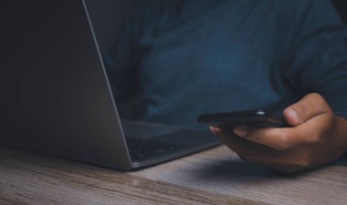 İşadamı bilgisayarlı akıllı telefon kullanıyor. El ele tutuşan cep telefonu mesajlaşması ile bize ulaşın. Sohbet etmek, internet bilgilerini aramak. Teknoloji aygıtı iletişimi.