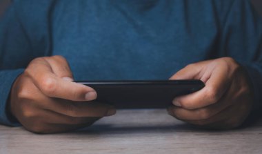 Adam cep telefonundan video izliyor. Akıllı telefonlu çevrimiçi film yayını. İnternette hayali bir video oynatıcı servisi ile video oyunu oynayan adam.