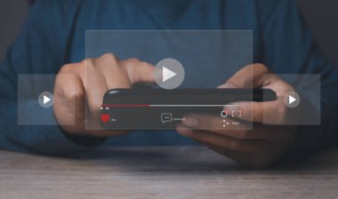 Cep telefonuyla video oyunu oynayan bir adam. Akıllı telefonlu çevrimiçi film yayını. İnternette hayali bir video oynatıcı servisi ile video izleyen kişi.