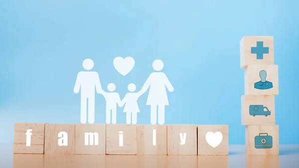 Family with insurance for your health concept. Wooden blocks with healthcare medical icons and family icons on blue background, copy space.