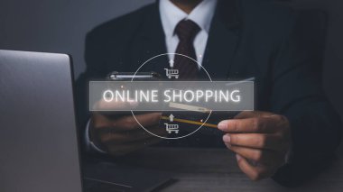 Cep telefonuyla kredi kartıyla alışveriş yapmak. İnternet üzerinden ikon e-ticaret işleriyle internet üzerinden cep telefonu ve kredi kartı alışverişi yapan bir işadamı. Boşluğu kopyala.