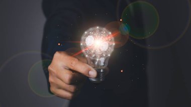 Yaratıcı fikir ve yenilik. Çevrimiçi teknolojinin ampullerini tutan bir iş adamı. İş, Geliştirme, Yaratıcı fikir, Yenilik kavramı.