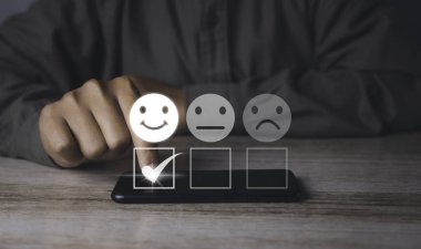 Customer satisfaction experience concept. Businessman choosing  happy smiley face icon to give satisfaction in service. rating very impressed. copy space.