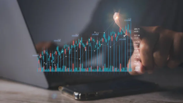 Stock Market Investments analysis and Digital Assets. Business finance technology and investment concept. Stock market graph with man working on laptop stock trading computer screen background.