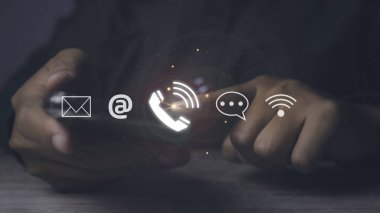 CONTACT US, İş adamı cep telefonu destek hattını kullanan insanlar iletişim simgeleriyle (e-posta, adres, canlı sohbet, İnternet Wi-fi) bağlantı kuruyor. Müşteri hizmetleri çağrı merkezi konsepti. Boşluğu kopyala.