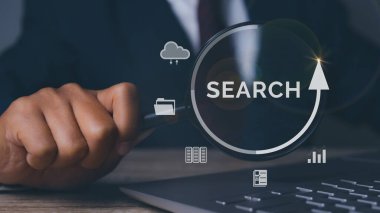 İş adamı, tabletle arama bilgi ağı kurmak için büyüteç kullanıyor. İş arama, iş bulma, iş görüşmesi. Veri Arama Teknolojisi Arama Motoru Optimizasyonu.