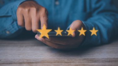 İşadamı dokunarak geri bildirim memnuniyet hizmeti için yüksek puan veriyor. Beş yıldız simgesi ile müşteri memnuniyeti deneyimi ve geri bildirim memnuniyet servisi için mükemmel.