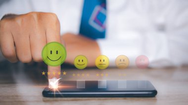 Akıllı telefonu mutlu gülümsemeyi seçen adam geri bildirim memnuniyet hizmeti için olumlu zihniyet seçimiyle karşı karşıya. Reyting çok etkileyici. En iyi kalite Müşteri memnuniyeti konsepti.