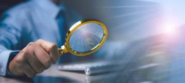 İş adamı, büyüteç kullanarak veri topluyor. İnternet dünyası arama teknolojisi hakkında bilgi Arama Motoru Optimizasyonu (SEO).