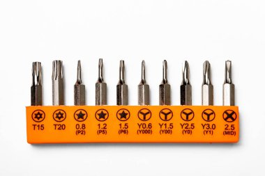 Set of Torx, Torx security, tri-point, pentalobe and MID magnetic precision screwdriver bits on white background clipart