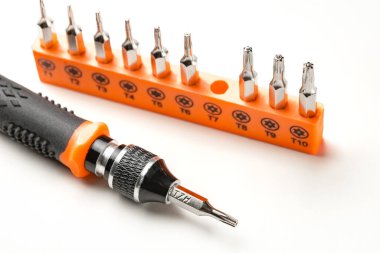 Torx ve torx güvenlik manyetik hassas tornavida parçaları ve beyaz arkaplanda siyah ve turuncu saplı.